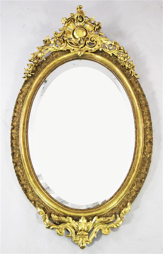 A large Victorian oval gilt wall mirror, 4ft 7in.